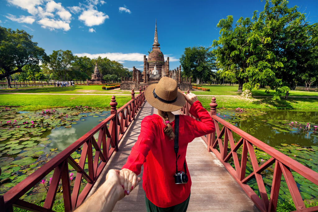 Woman walking across bridge while traveling in Thailand