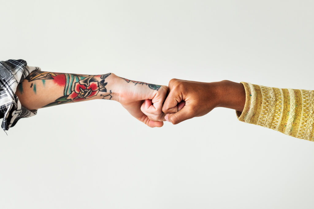 Two people fist bumping each other